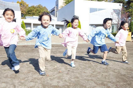 手を繋いで園庭を走る幼稚園児5人