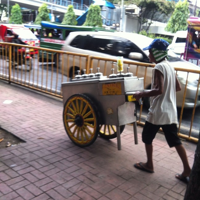 A Sorbetero peddling his colorful cart around the city.