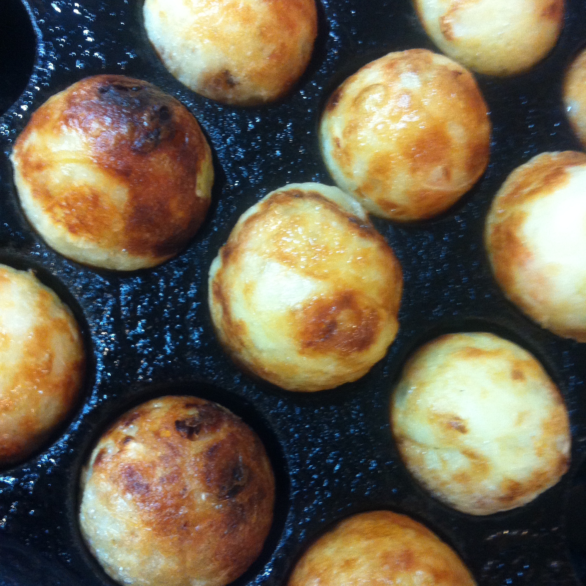 Takoyaki being prepared in the pan.