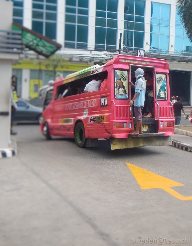 A Konduktor is often seen at the back of the jeepney.