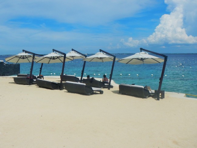 Relax and enjoy the breathtaking view on a hot, sunny day with these parasol-protected lounging chairs.